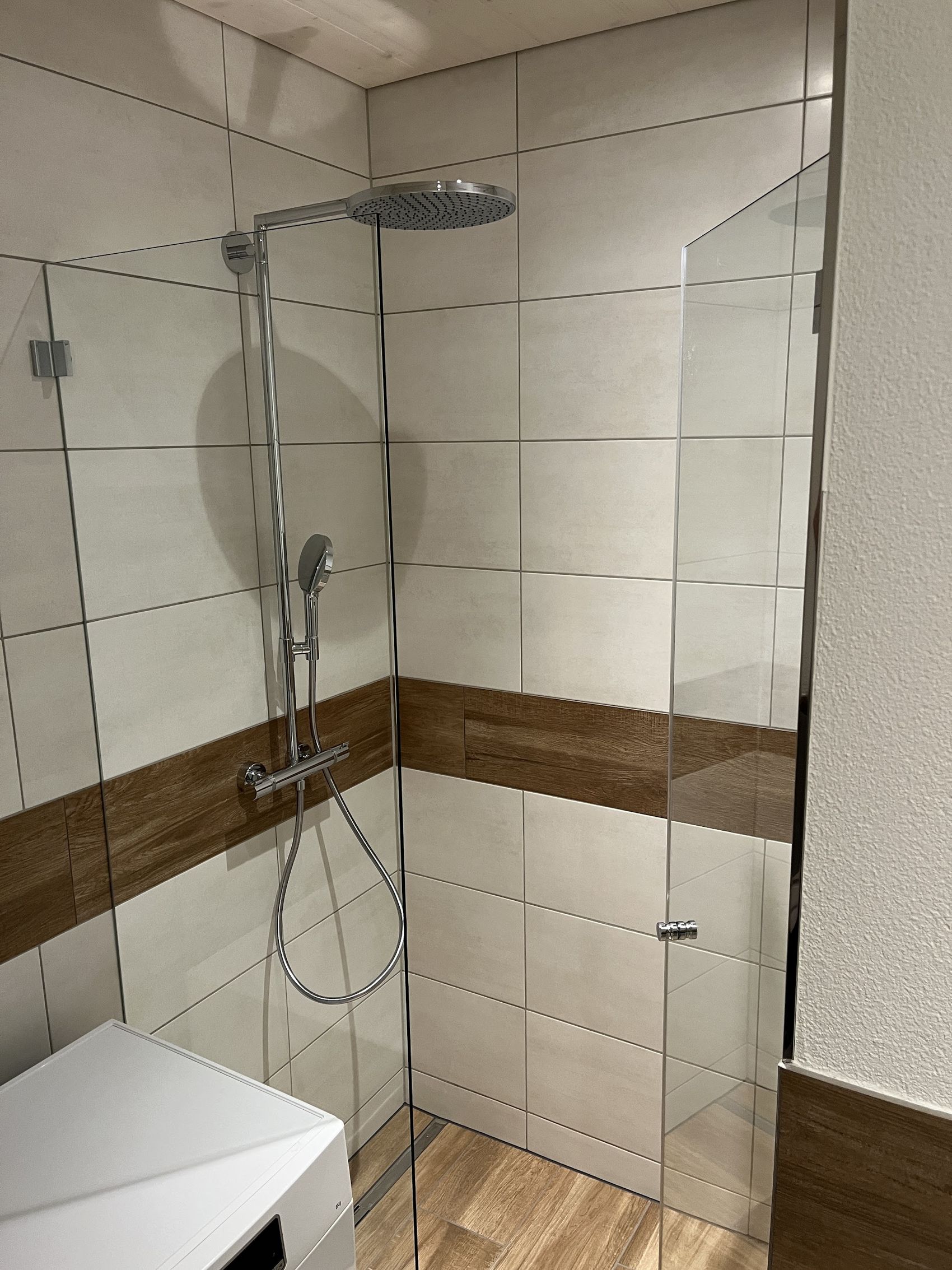 Dusche mit Glaswand, Holzoptik-Band und Holzoptik-Boden