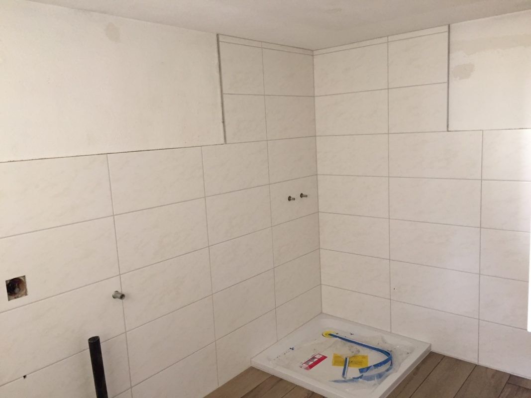 Fertig geplattete Wand mit Duschtasse
