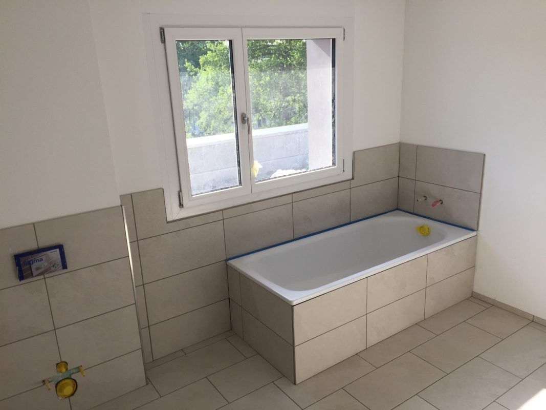 Badewanne eingeplattet mit hellen Wandplatten
